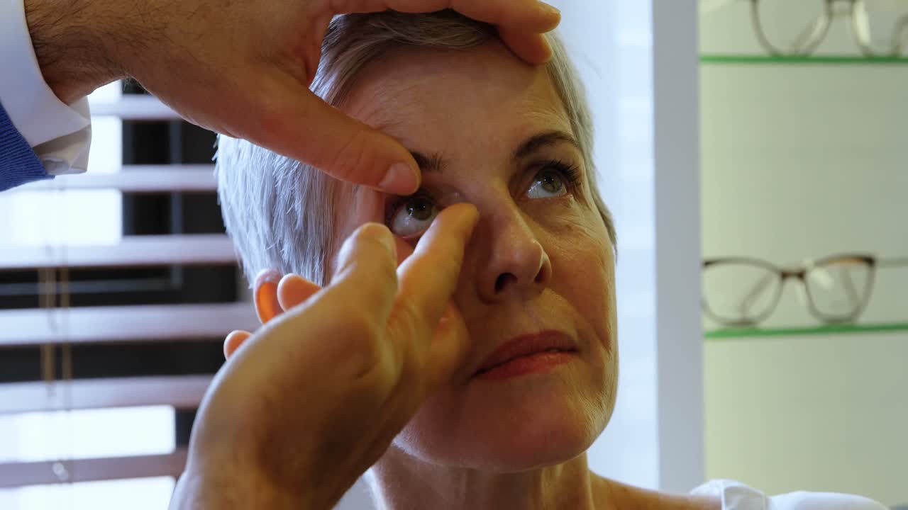 optometrista poniendo lentes de contacto al paciente 4k