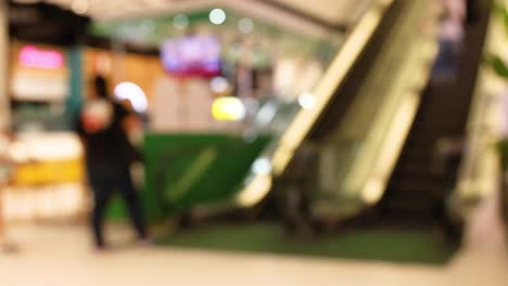 people using escalator in bustling shopping center