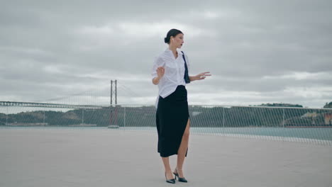 business lady calling wireless earbuds in front cloudy sky. girl talking headset