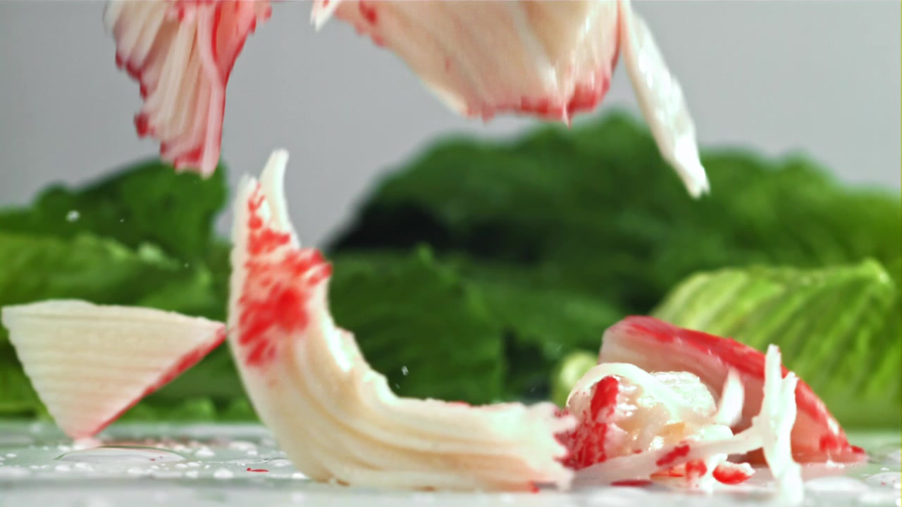 Movimento rallentato di surimi che cade su una superficie bagnata