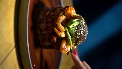 vertical slow motion close-up of female hand woman eating a seafood shrimp timbale at a traditional mexican restaurant