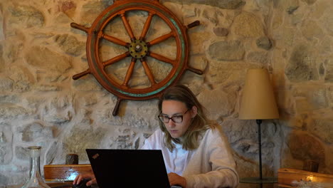 joven gerente femenina asistiendo a su negocio en línea en la computadora portátil