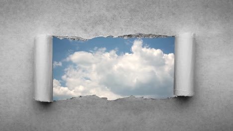 un video creativo de 4k de nubes que se mueven rápidamente en el cielo azul que son visibles a través de un agujero con bordes rasgados en viejo papel vintage retro grunge.