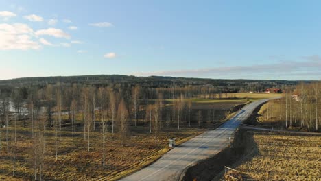 Drone-footage-high-rising-at-the-side-of-a-road-at-autome