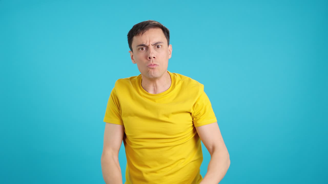 Man expressing emotions in yellow shirt
