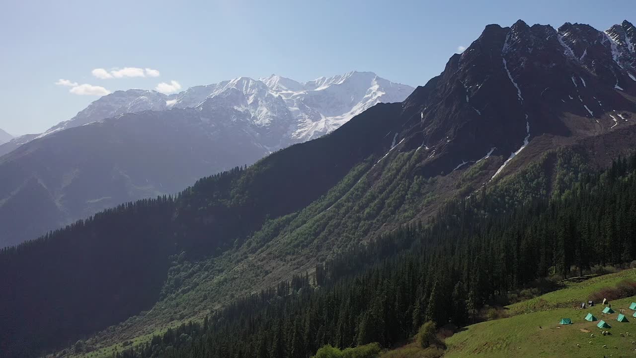 hermoso bosque frondoso y montañas nevadas vistas desde la caminata sar pass - toma aérea