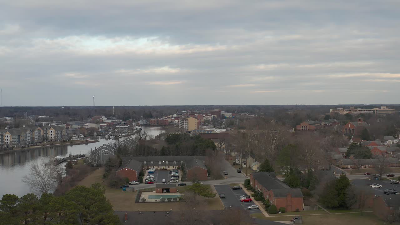 un dron vuela sobre casas y edificios al lado de un río