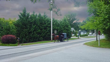 Un-Caballo-Amish-Y-Un-Buggy-Viajando-Por-Una-Carretera-Rural-Mientras-Se-Acerca-Una-Tormenta-En-Un-Día-De-Verano