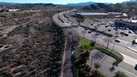 Aerial-drone-perspective-of-group-of-cyclists-riding-on-bike-path-in-California-next-too-freeway