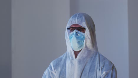 retrato de un trabajador médico caucásico con ropa de protección con máscara y gafas de seguridad