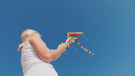 young woman playing with kite bottom view