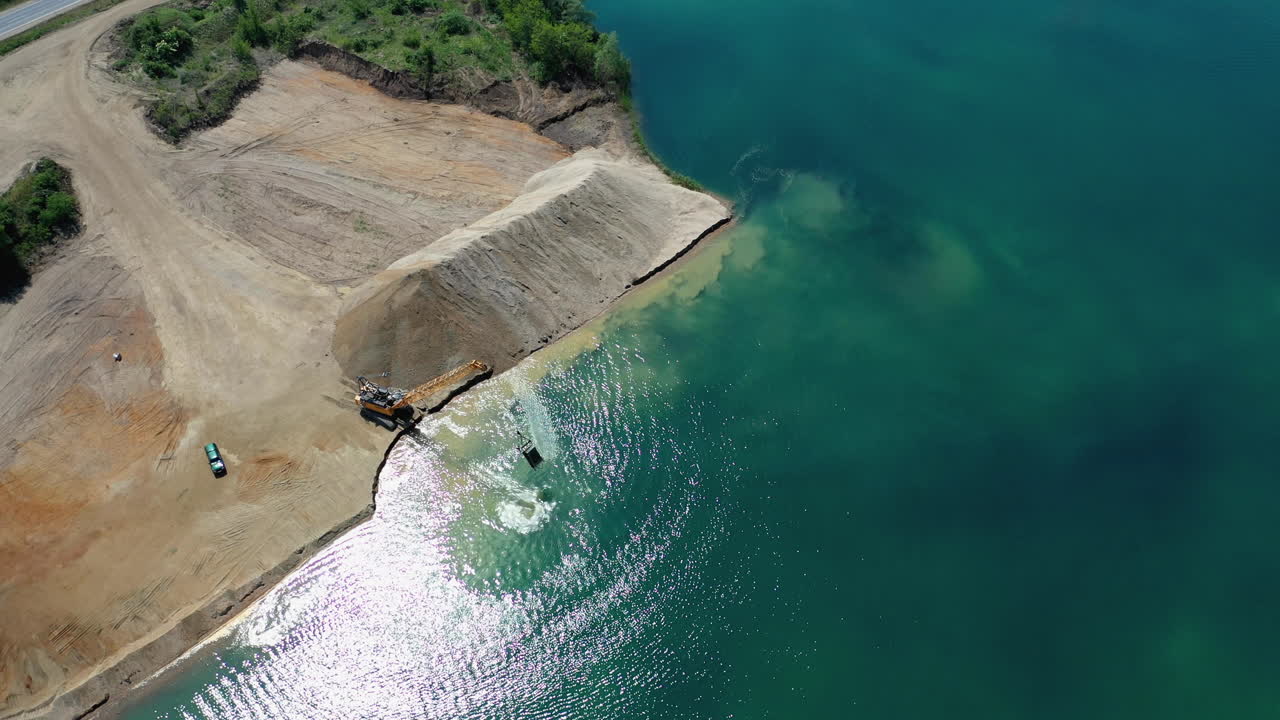 호숫가에서 굴삭기와 돌을 움직이는 꾸준한 공중 전망