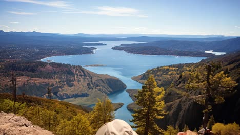 couple enjoying a scenic overlook at a lake in autumn sunlight