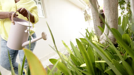 Happy-african-american-senior-woman-doing-houseworks-and-smiling,-slow-motion