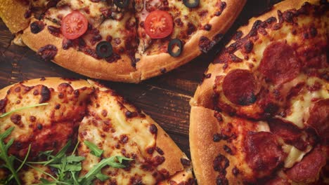 Various-kinds-of-pizzas-placed-on-wooden-table