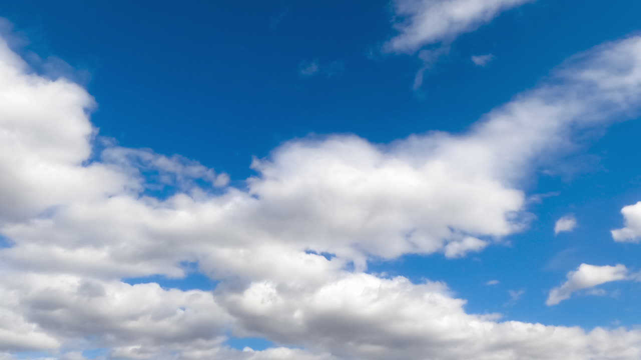 White thick clouds flying quickly by the skies. Rainy clouds formation in the atmosphere. Low angle view. Timelapse.
