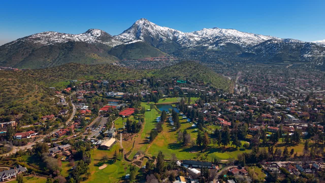 Aerial Drone fly La Dehesa Golf Club in Lo Barnechea, Santiago de Chile, with Manquehuito and Manquehue Snowy Peaks