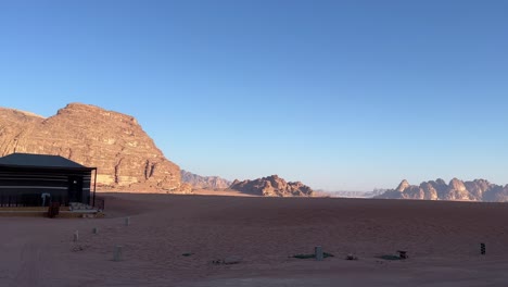 una amplia toma de establecimiento de las vastas arenas rojas del desierto de wadi rum, con un campamento de beduinos en jordania 4k toma estable