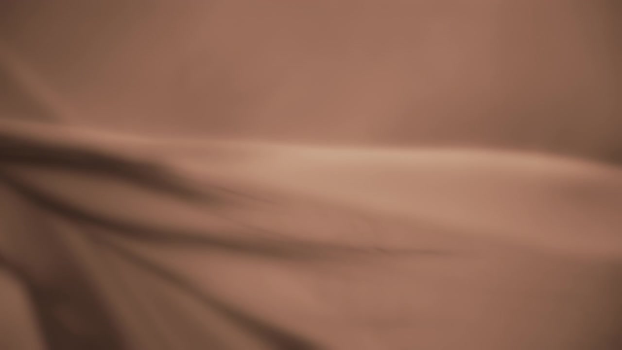 Creamy beige chiffon wavy fabric flowing in the wind