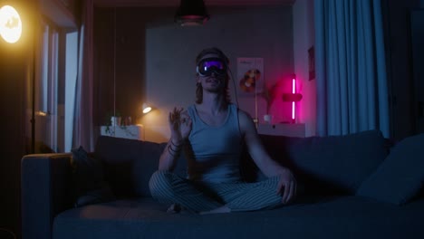 hombre usando auriculares vr en un sofá por la noche.