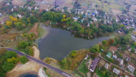 aerial view of a small village with a lake and surrounding fields