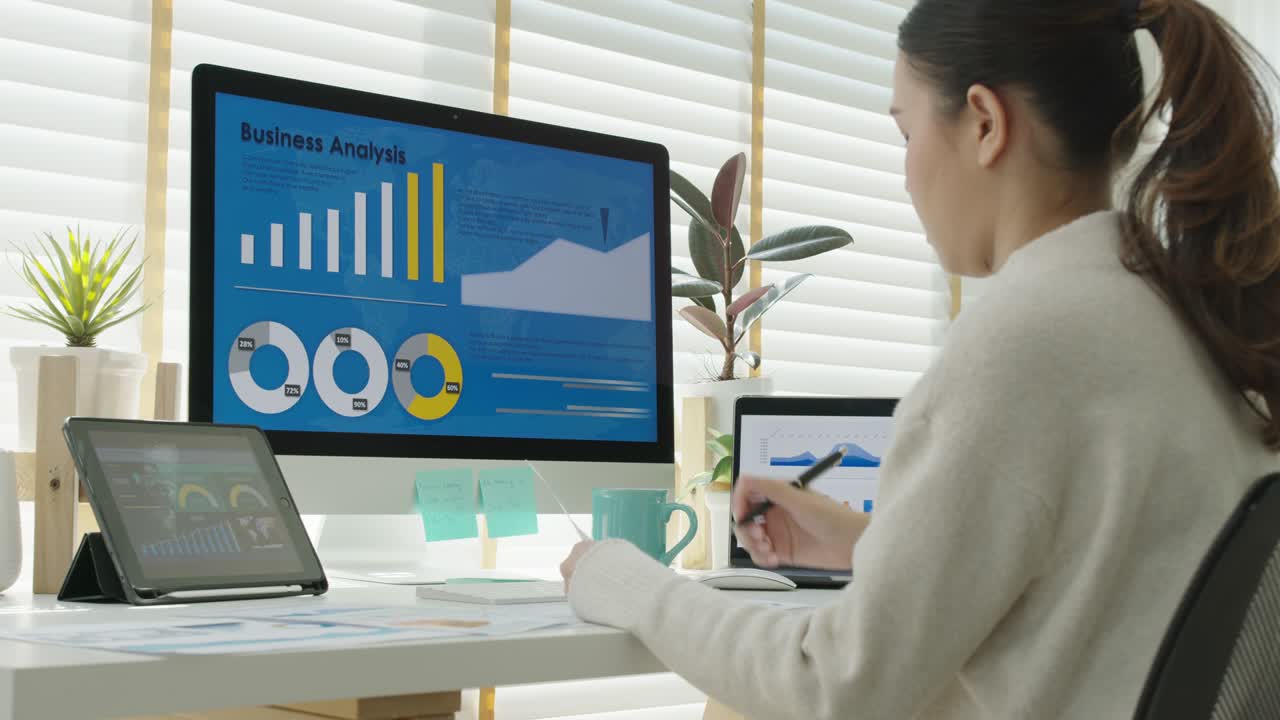 Young attractive asian thai woman employee busy work online multiple screen laptop computer or smart tablet at home in freelance sale data analytic, data science scientist engineer for business.