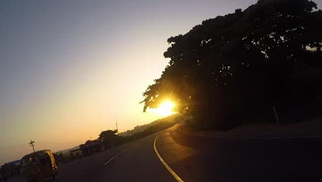 Andar-En-Bicicleta-En-La-Carretera-Sobre-El-Amanecer-Hacia-El-Sol-Con-Un-Punto-De-Vista-De-Un-Ciclista---V