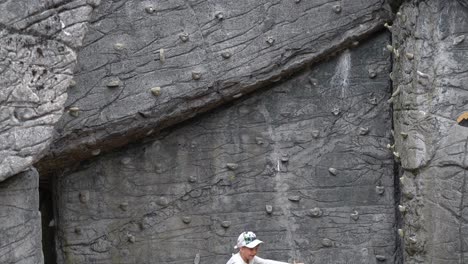 Seven-year-old-girl-smiles-proudly-to-parents-and-camera-after-climbing-up-a-climbing-wall