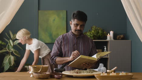 man reading an ayurveda recipe book