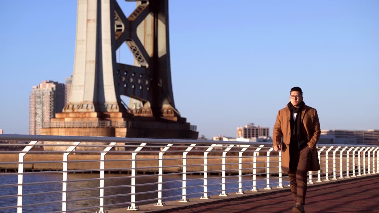 캠든, 뉴저지 - 맑고 푸른 하늘을 배경으로 카메라를 향해 걸어가는 아시아 한국인 관광객 - 스테디 샷