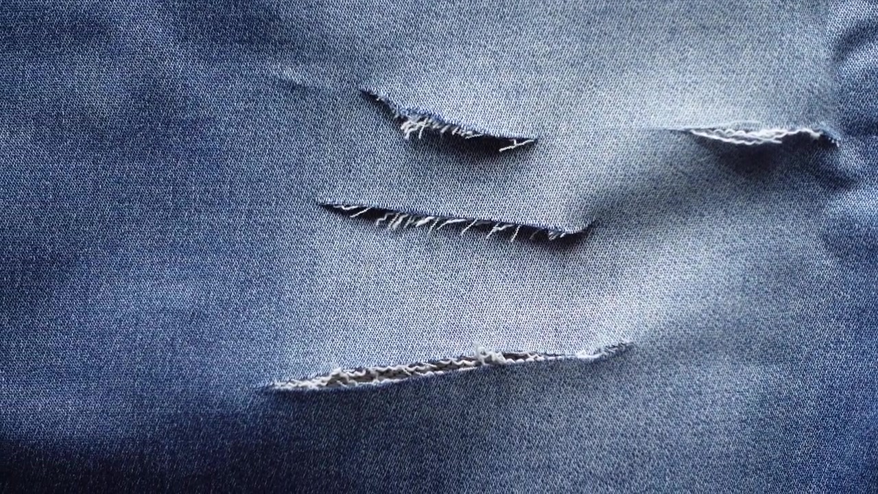 Close-up of Distressed Blue Denim Fabric Texture