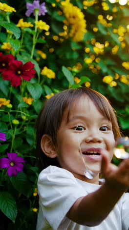 joyful child playing with water droplets in a sunny garden