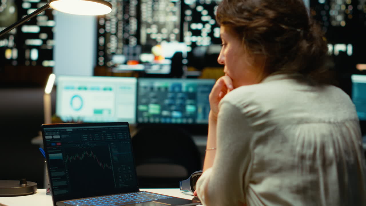 Employee monitors live stock market trends and cryptocurrency exchanges