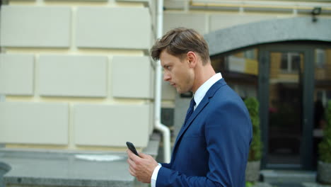 Serious-business-man-using-mobile-phone-online-outdoors