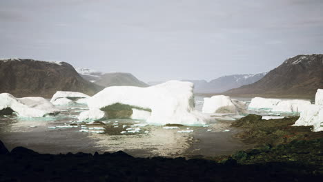 Montañas-Nevadas-E-Icebergs-A-La-Deriva-En-El-Mar-De-Groenlandia