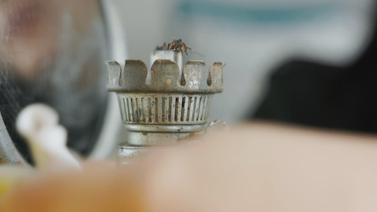 거울 반사와 함께 여성에 의해 청소되는 빈티지 가스 램프의 버너