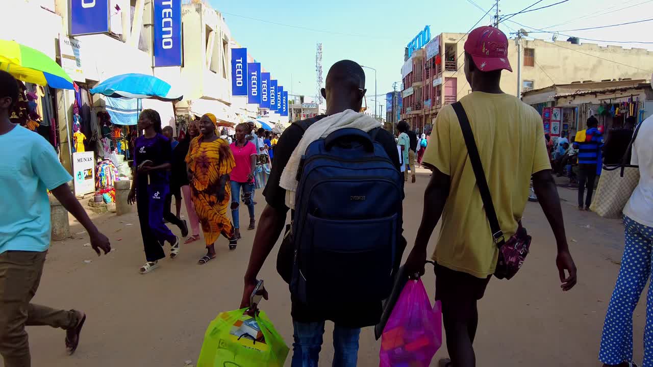 POV shot walking through the crowded Serekunda Market, sunny day in Gambia