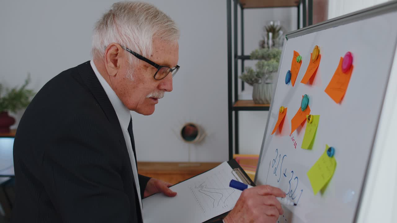 hombre de negocios senior haciendo notas a bordo con pegatinas analizando infografías usar computadora portátil