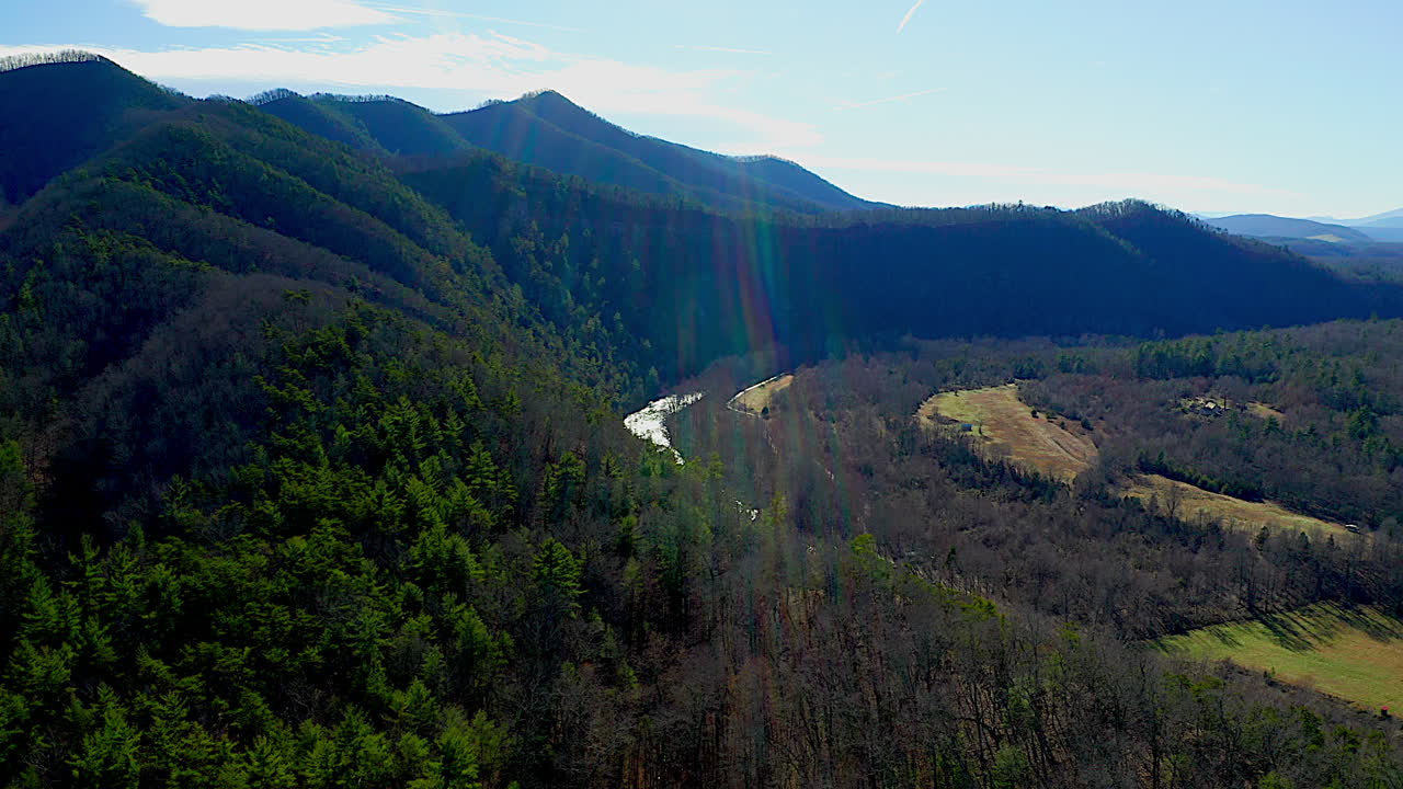 toma panorámica de montañas, valles y ríos en un día soleado