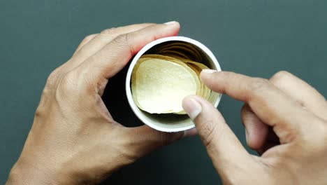 Top-view-of-hand-pick-a-chips-from-a-container-,