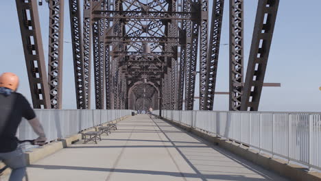 view looking down the center of the big four bridge in louisville kentucky with biker passing camera and riding away with push forward