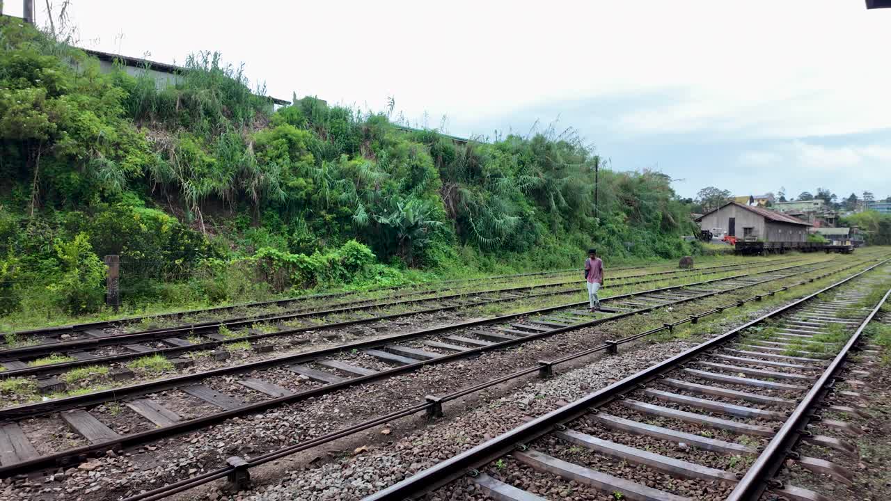Man Walking on Train Tracks in Sri Lanka