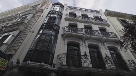 beautiful slow motion zoom in shot of a classic building in the center of madrid with trees around it on de goya street in madrid, spain.