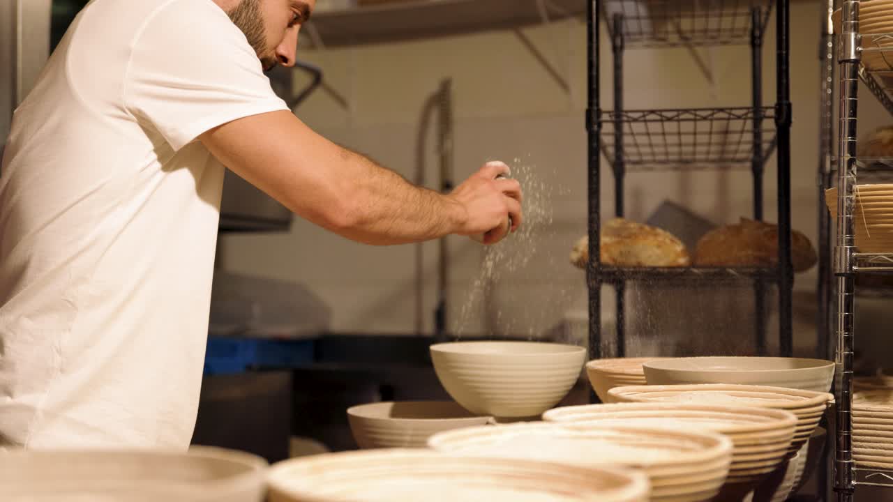 Baker Sprinkling Flour into Bowls in a Commercial Kitchen