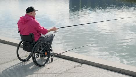 person with a physical disability who uses wheelchair fishing from fishing pier