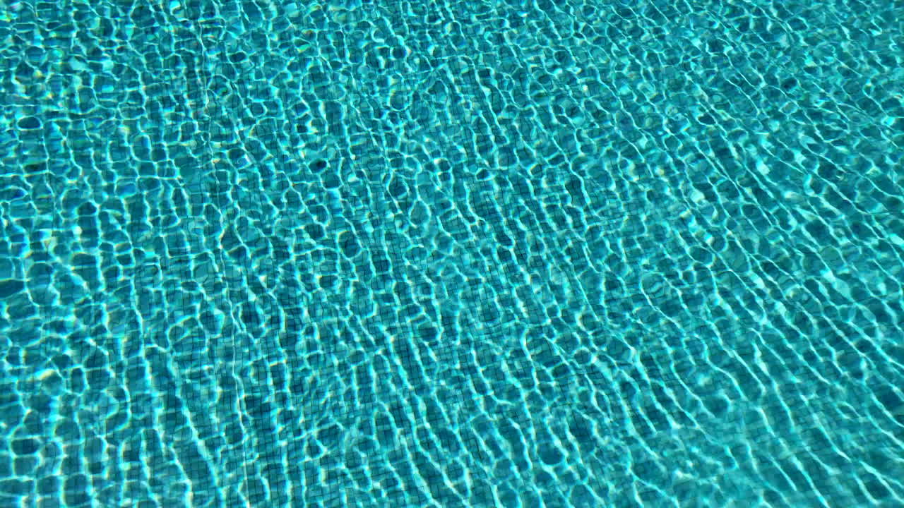 4k-aufnahmen von im sonnenlicht schimmerndem schwimmbadwasser