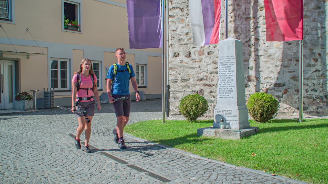 Two young hikers visiting St Vitus church, a romanesque building in Dravograd, Slovenia