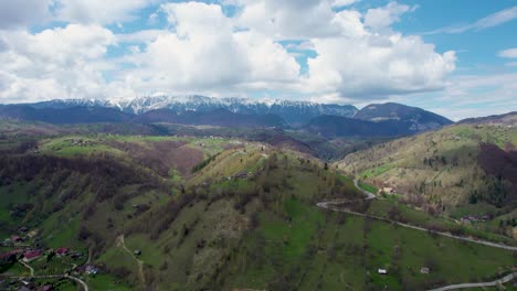 el esplendor indomable de piatra craiului - una visión aérea impresionante de los picos cubiertos de nieve, un pueblo pintoresco, y la exuberante vegetación en rumania, transilvania, moieciu, rucar, bran