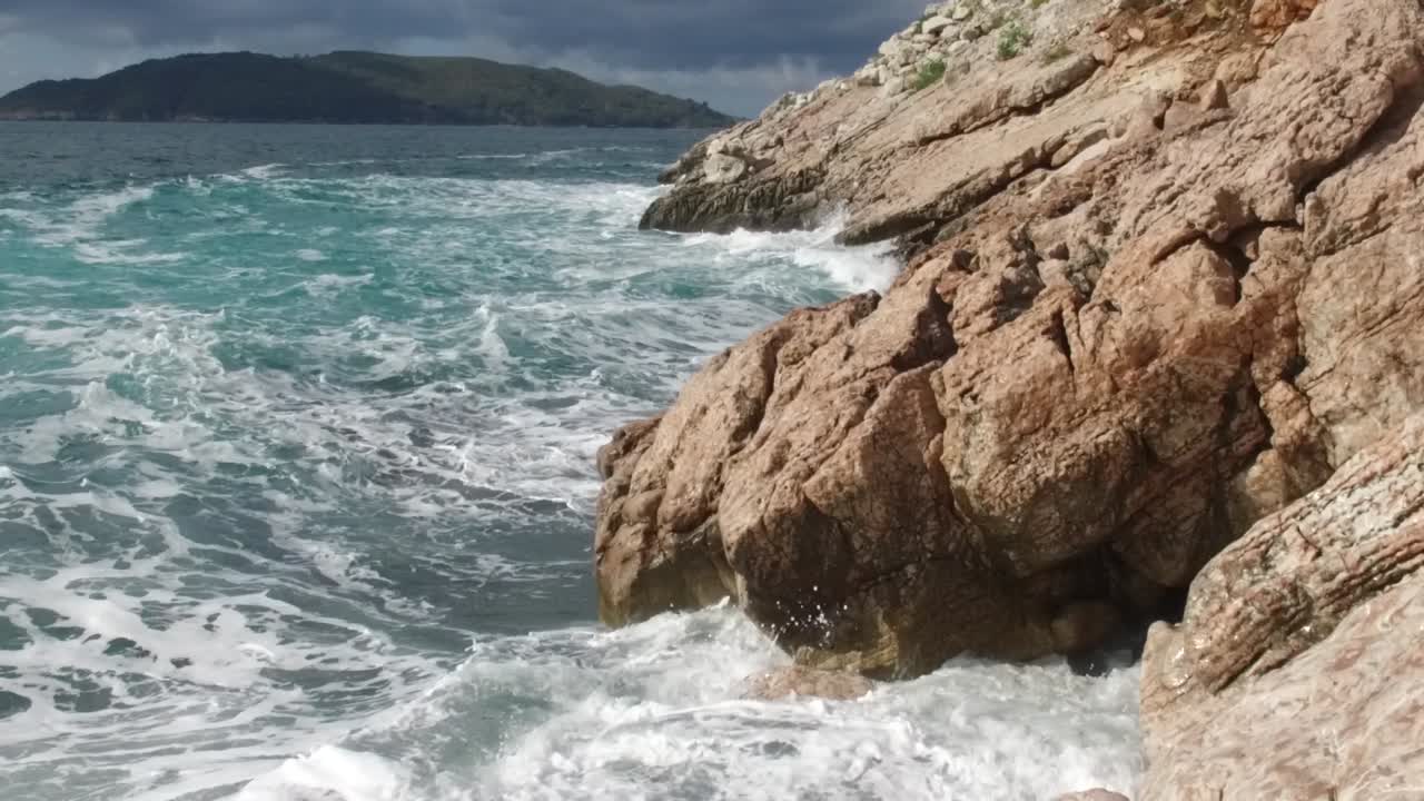 Le onde dell'oceano si scontrano con le rocce