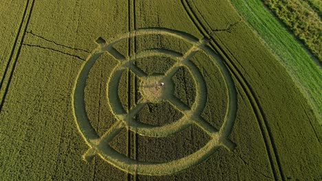 hackpen hill strange crop circle pattern in rural grass farming meadow aerial view birdseye pull back shot